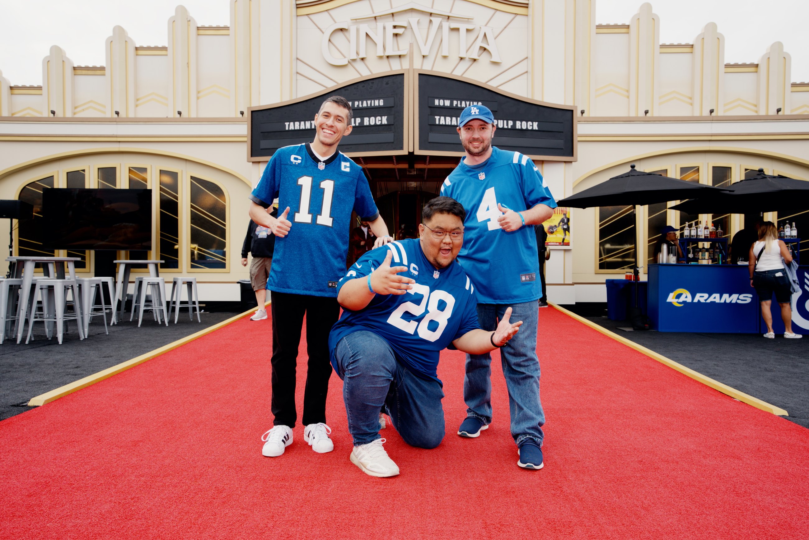 Rams fans posing on a red carpet outside a branded CineVita activation
