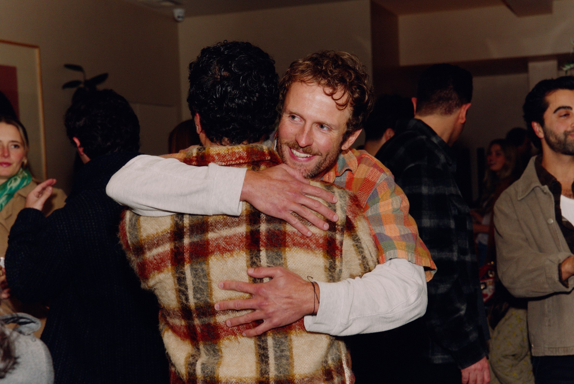 Two guests hugging at a warm social event