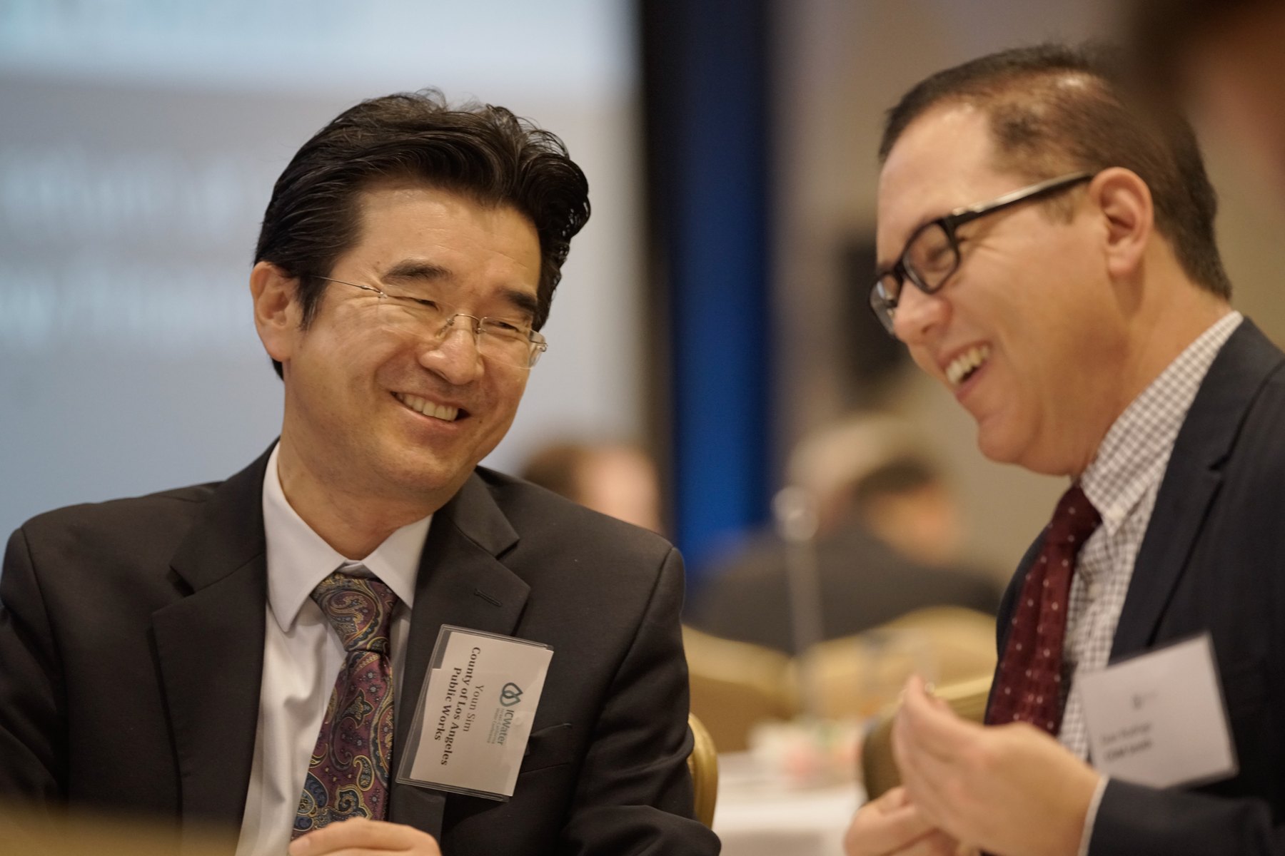 Two guests laughing during a professional event