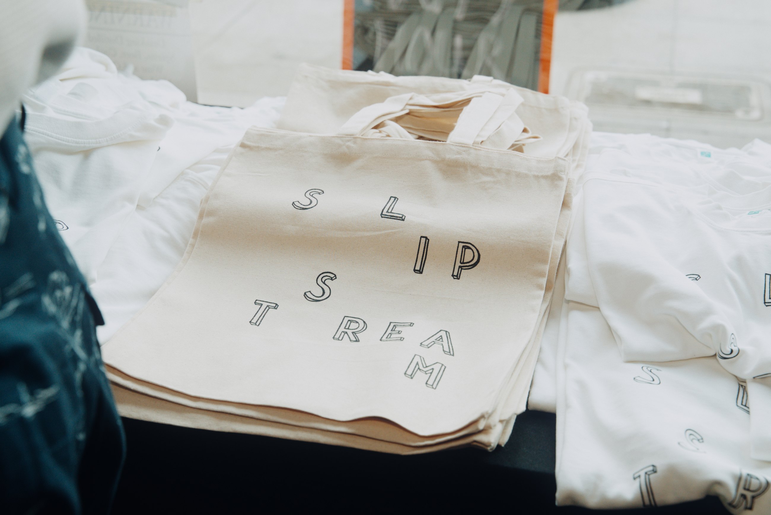 Branded tote bags stacked at an event