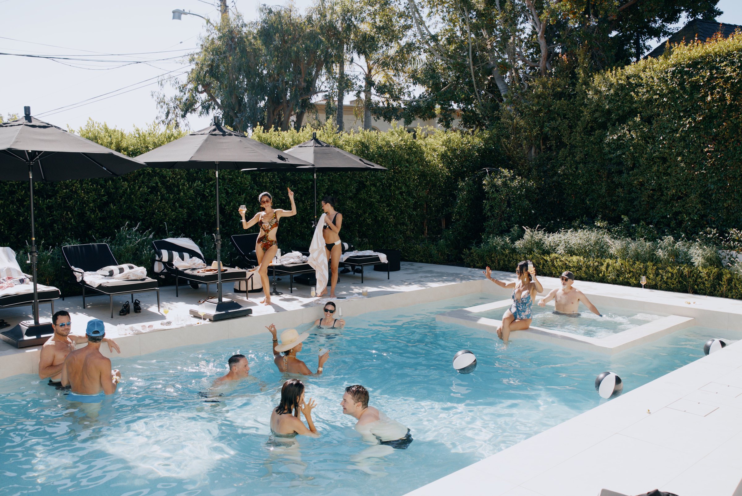 Guests in and around a bright pool at a private event