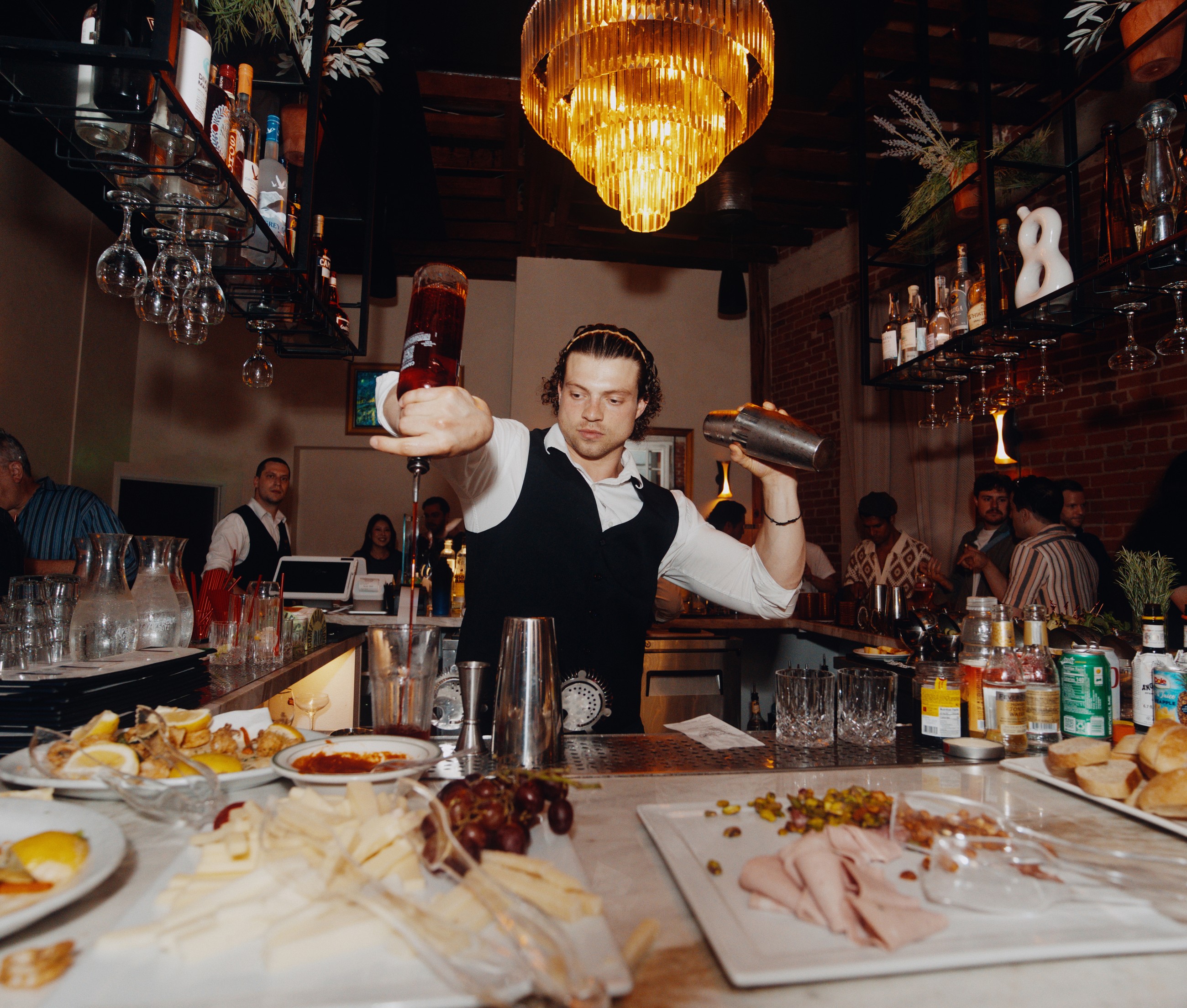 A bartender working inside a designed hospitality setting