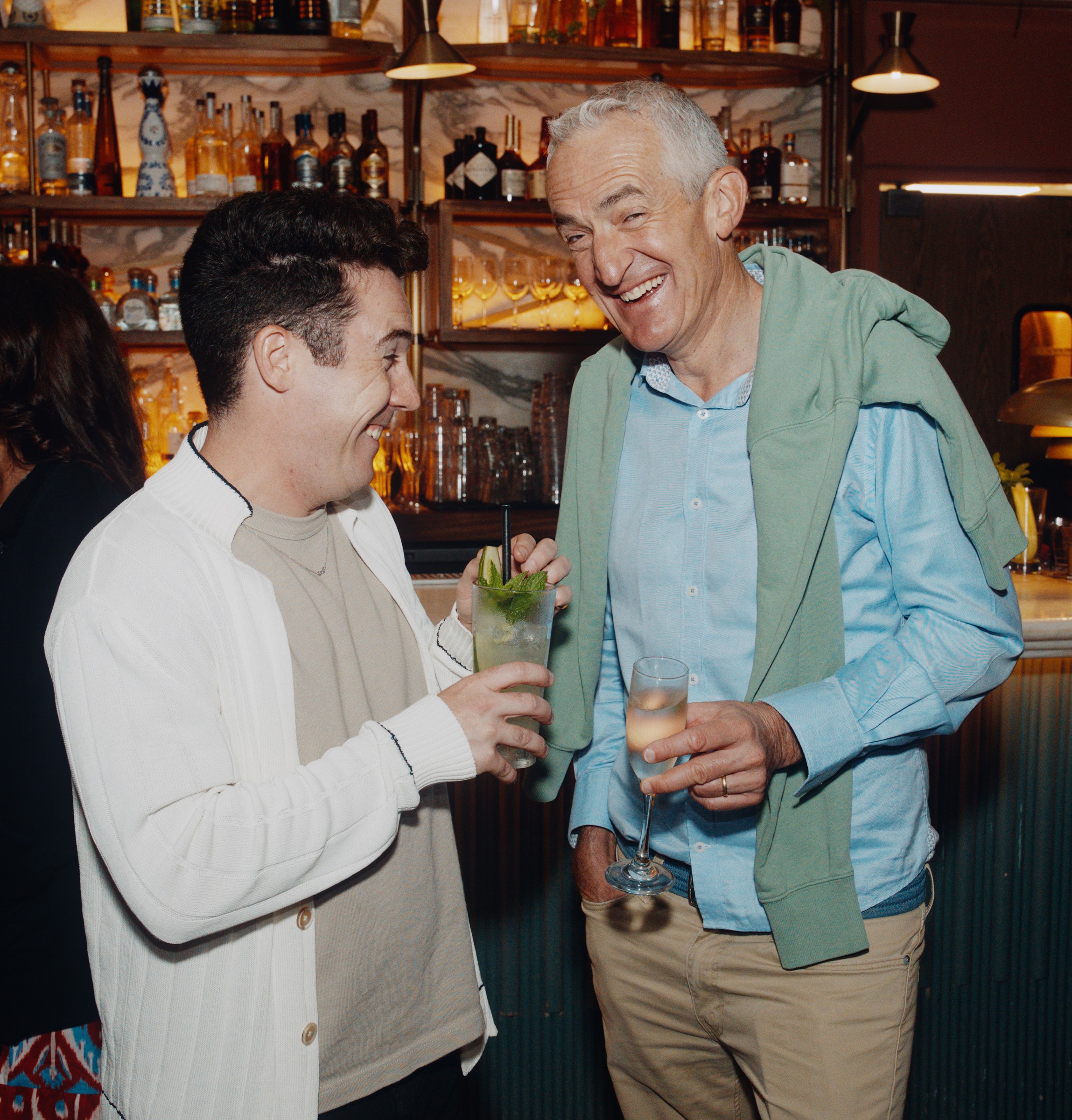 Two guests laughing together at a social event bar